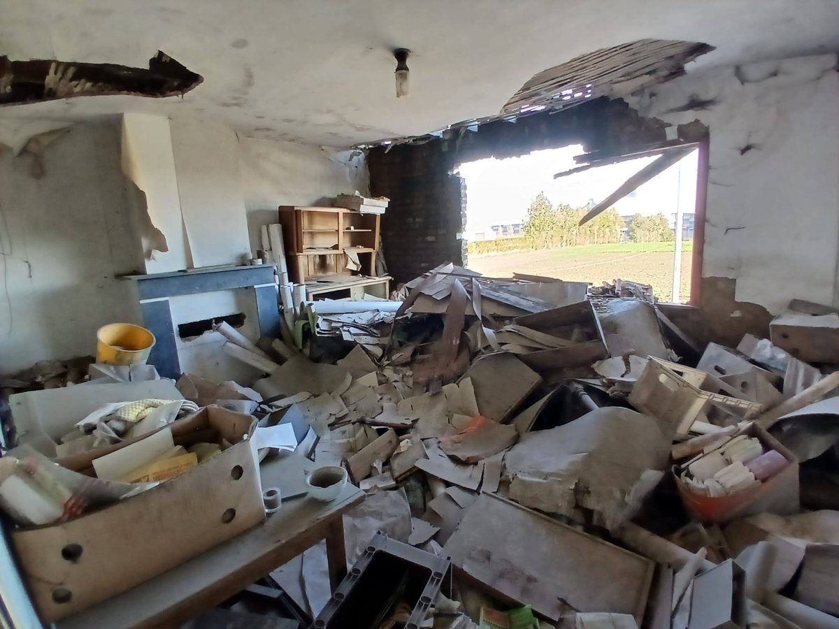 Vendre sa maison sans la vider, en Belgique ou en France 4 Pièce remplie de cartons, de planches et de débris, avec un trou dans le mur, dans une maison visitée en Belgique