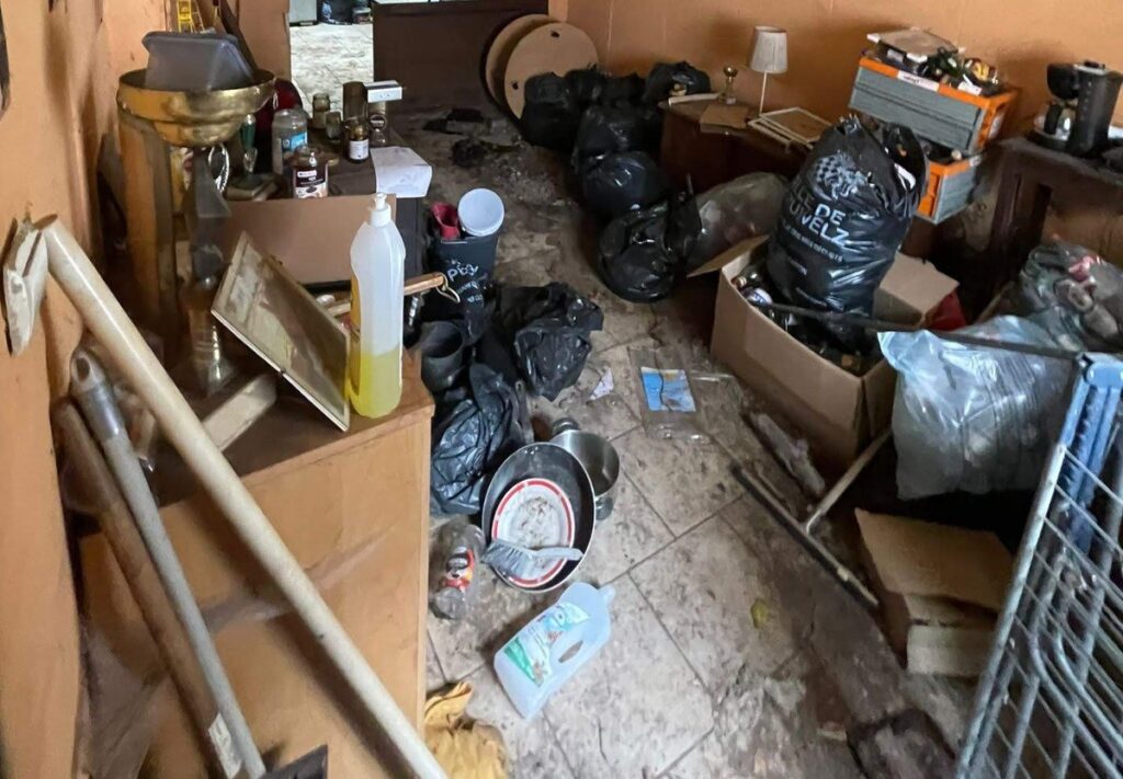 Pièce encombrée de sacs, de cartons et d'objets, dans une maison pleine que nous avons visitée en Belgique